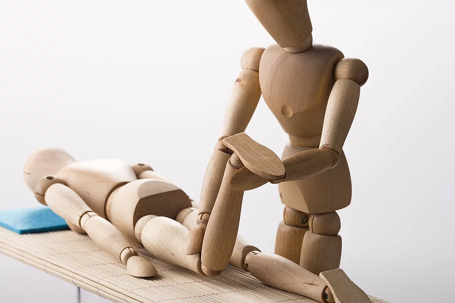 Orthopädie Holzfiguren: Osteopathische Behandlung