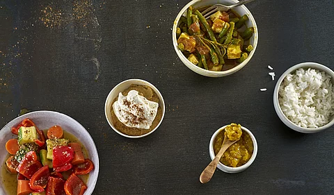 Tableau mit ayurvedischen Lebensmitteln: Reis, Gewürze, gekochtes Gemüse