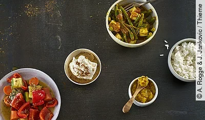 Tableau mit ayurvedischen Lebensmitteln: Reis, Gewürze, gekochtes Gemüse