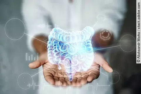 Ein Doktor hält einen holographischen Darm in den Händen. 