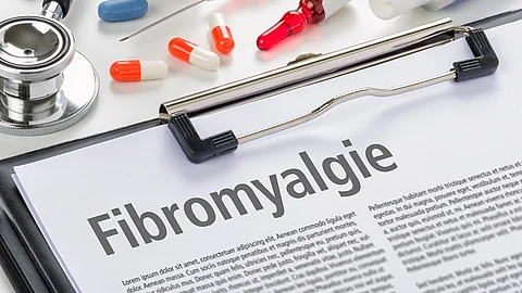 Fibromyalgie geschrieben auf Klemmbrett umgeben von medizinischen Utensilien