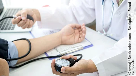 Ein Arzt checkt den Blutdruck eines Patienten.