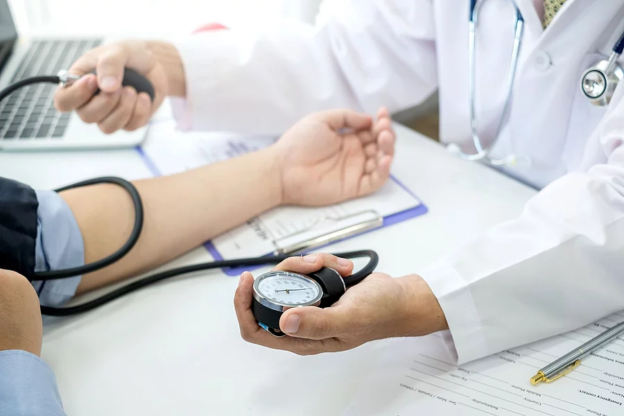 Ein Arzt checkt den Blutdruck eines Patienten.
