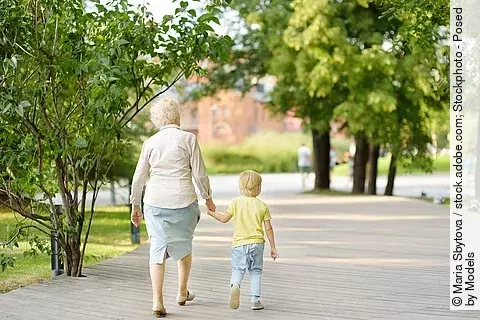 Oma mit Enkel an der Hand beim Parkspaziergang 