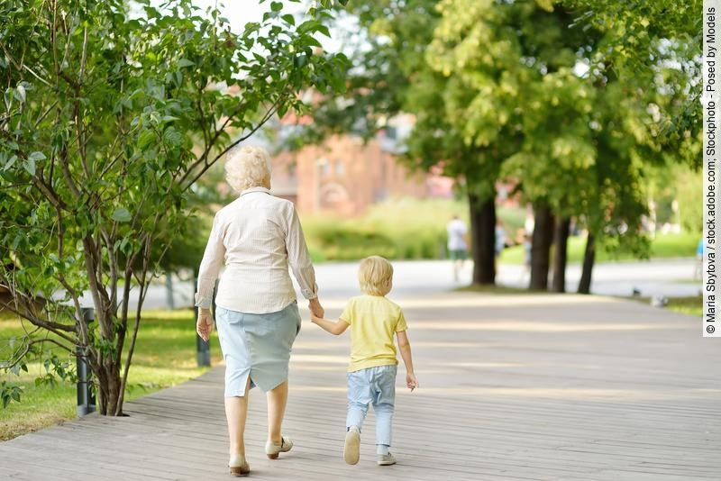 Oma mit Enkel an der Hand beim Parkspaziergang 