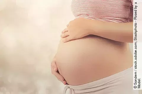 Schwangere Frau hält sich den Bauch