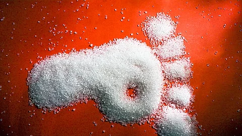 Fußabdruck aus Zucker auf rotem Hintergrund. 