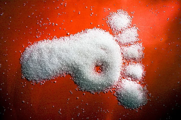 Fußabdruck aus Zucker auf rotem Hintergrund. 