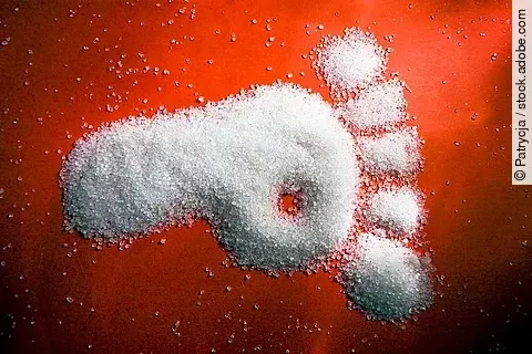 Fußabdruck aus Zucker auf rotem Hintergrund. 