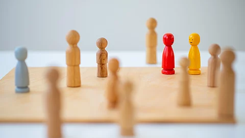 Familienaufstellung, kleine Holzfiguren auf einem Holzbrett