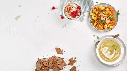Tableau mit kleinen Mahlzeiten: Suppe, Brot, Gemüse mit Fisch, Haferflockenmüsli mit Himbeeren