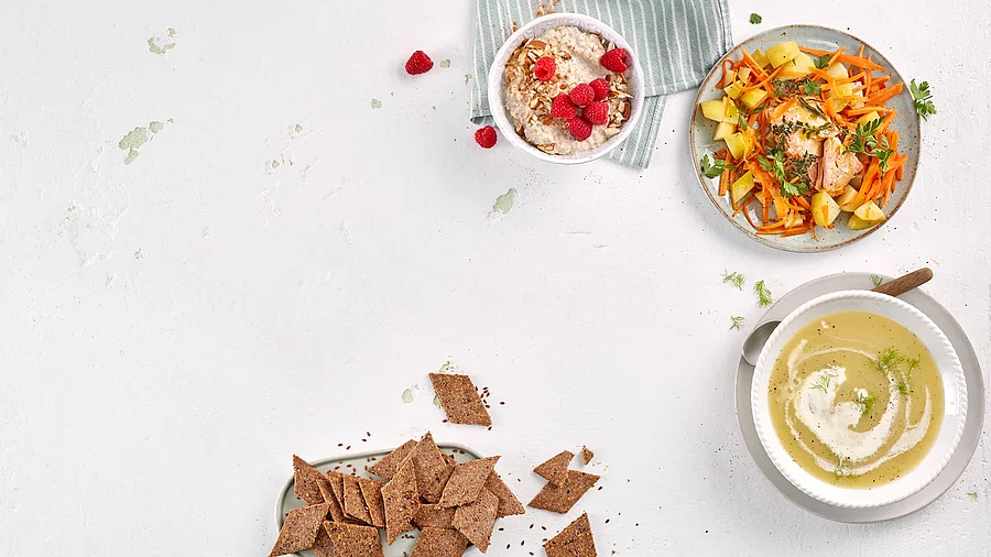 Tableau mit kleinen Mahlzeiten: Suppe, Brot, Gemüse mit Fisch, Haferflockenmüsli mit Himbeeren