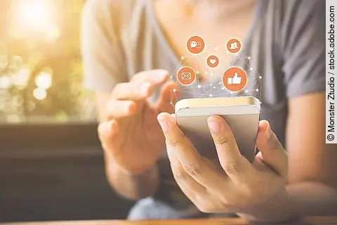 Frau, die ihr Smartphone benutzt und drum herum erscheinen Icons (Facebook, E-Mail, Messenger)