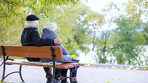 Senioren-Paar sitzt auf einer Bank im Park. 