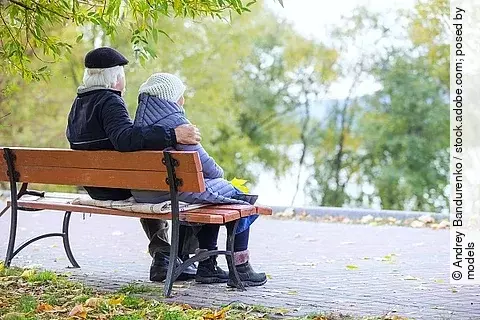 Senioren-Paar sitzt auf einer Bank im Park. 