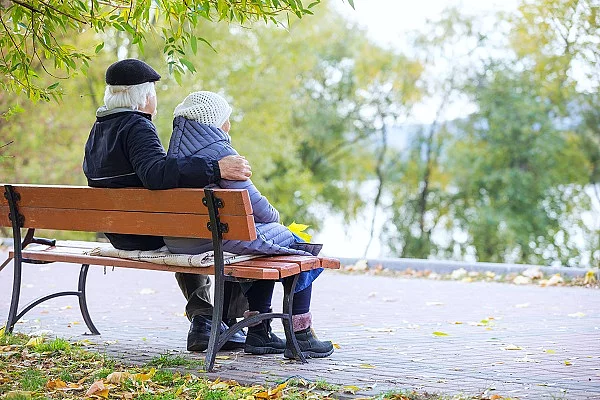 Senioren-Paar sitzt auf einer Bank im Park. 