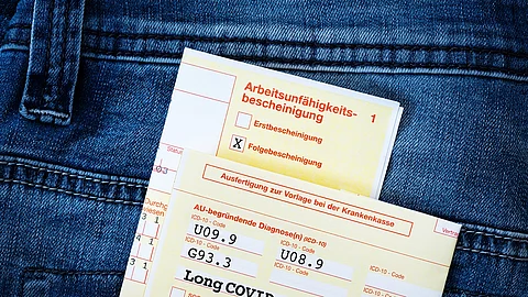 Long Covid Krankmeldung AU-Formular in der Gesäßtasche einer Jeans