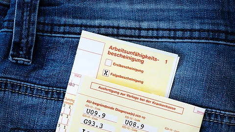 AU-Schein in einer Jeans-Gesäßtasche