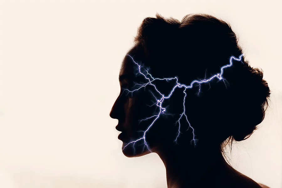 Silhouette eines Frauenkopfs mit Blitzen im Kopf