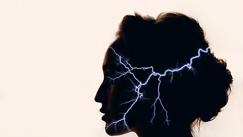 Silhouette eines Frauenkopfs mit Blitzen im Kopf