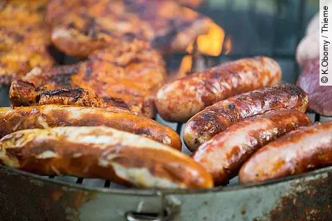 Würstchen und Fleisch auf einem Grill.