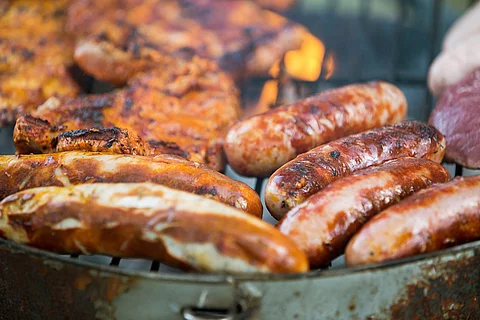 Würstchen und Fleisch auf einem Grill.