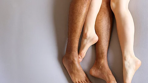 Beine eines Paars, Männer- und Frauenbeine im Bett