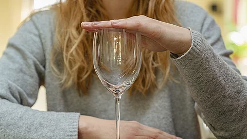 Frau hält leeres Weinglas zu