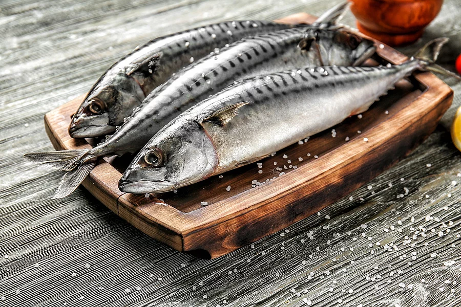 Board with tasty raw mackerel fish on wooden table Frische Makrelen auf einem Holzbrett