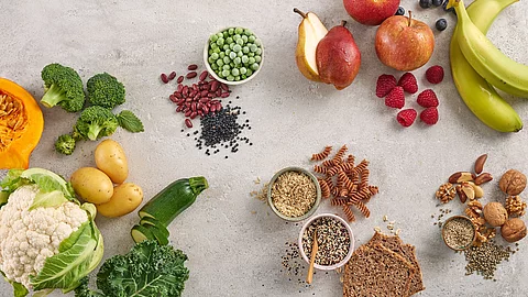 Tableau mit gesunden Kohlenhydratlieferanten: Obst, Gemüse, Hülsenfrüchte, Vollkorn, Beeren