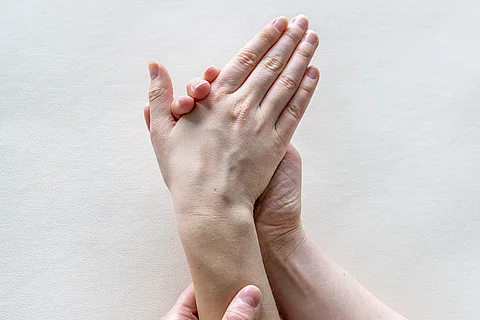 Hand zieht Handgelenk nach rechts
