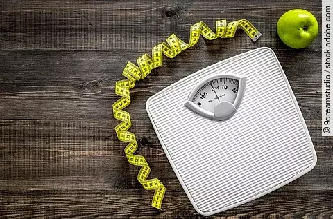 Waage, Maßband und Apfel