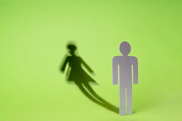 Symbolbild Transgender, Mann zu Frau mit Schatten auf grünem Hintergrund