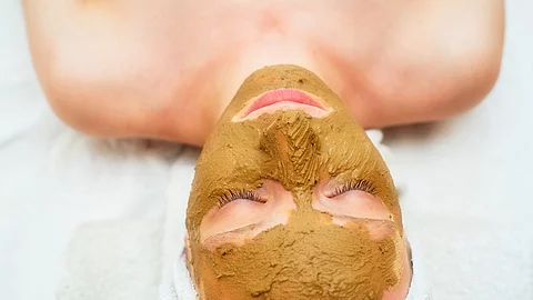 Frau hat eine Heilerdemaske im Gesicht.