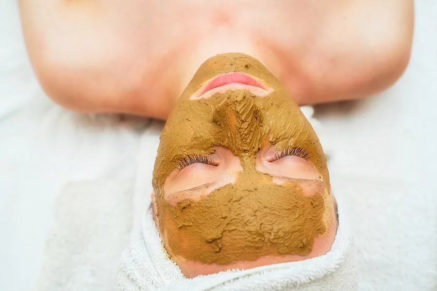 Frau hat eine Heilerdemaske im Gesicht.