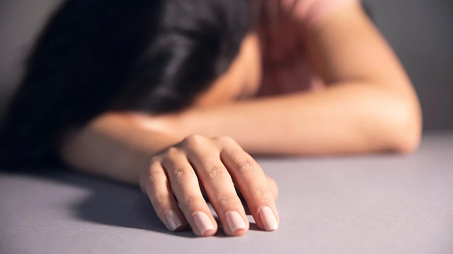 Erschöpfte Frau mit dem Kopf auf dem Tisch