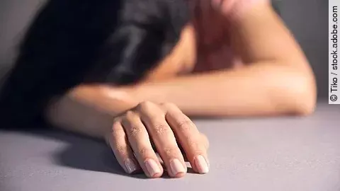 Erschöpfte Frau mit dem Kopf auf dem Tisch