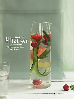 Wasser mit Beeren und Gurkenscheiben in einem Krug.