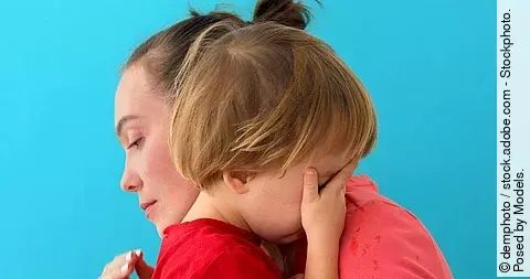 Frau umarmt ein Kind