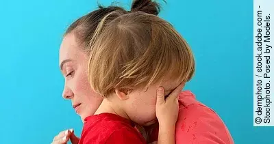 Frau umarmt ein Kind