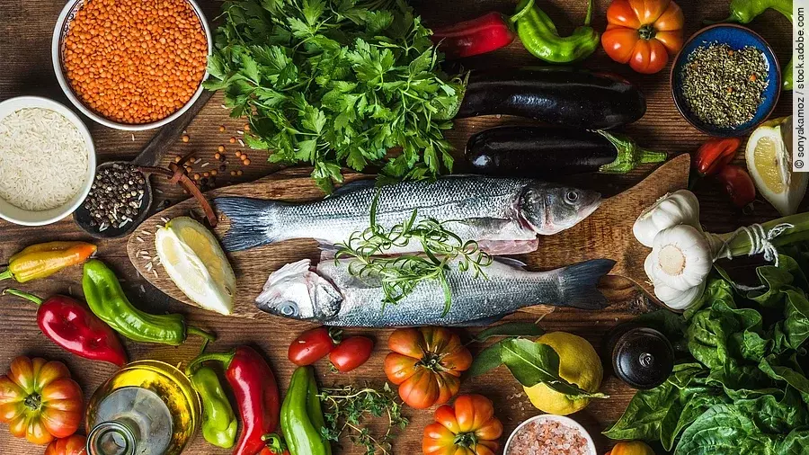 mediterrane Lebensmittel: Fisch, frisches Gemüse, Olivenöl, Hülsenfrüchte, Knoblauch, Zitrone, Kräuter