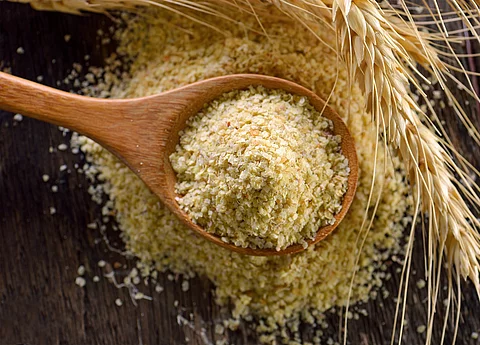 Weizen: Ähren und Keime auf einem Holzlöffel