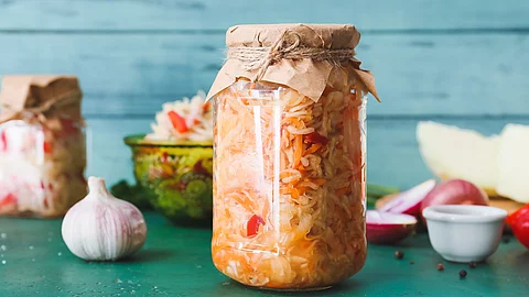 Fermentierte Lebensmittel, im Fokus ein Glas mit eingelegtem Kraut