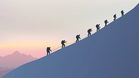 Acht Bergsteiger besteigen einen schneebedeckten Berg.