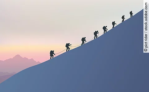 Acht Bergsteiger besteigen einen schneebedeckten Berg.