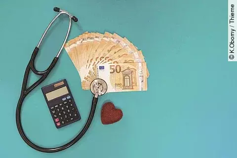 Stethoskop, Geldscheine, Taschenrechner und Stoffherz auf blauem Untergrund.