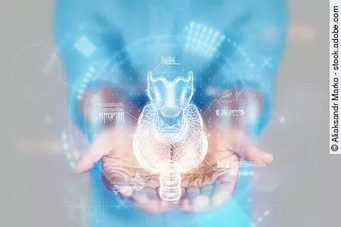 Unkenntliche Person mit gestreckten, ausgebreiteten Händen, die eine technische Darstellung der Schilddrüse hält