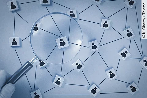 In einer schematischen Darstellungen sind Personen über ein Netzwerk verbunden. Eine Lupe vergrößert einen Ausschnitt des Netzwerks. 