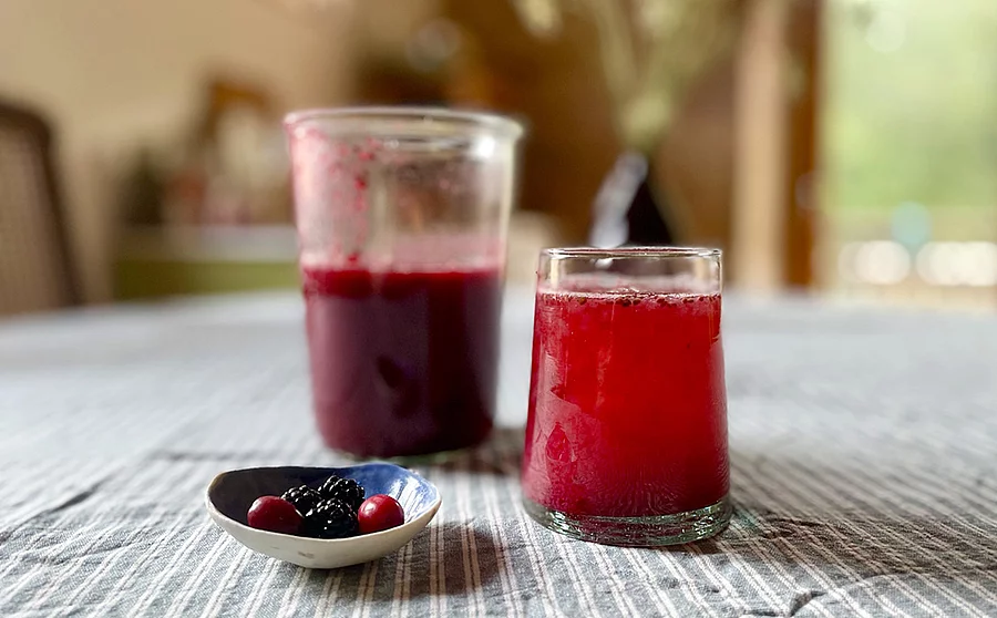 Fruchtoxymel aus Brombeeren und Kornelkirschen in einem Glas auf einem Tisch