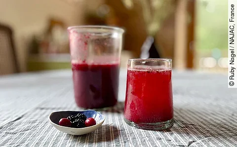 Fruchtoxymel aus Brombeeren und Kornelkirschen in einem Glas auf einem Tisch